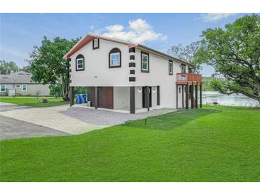 Two-story house with water view, attached garage, and landscaped lawn at 430 N Omaha St, Lake Hamilton, FL 33851