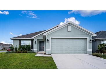 One-story house with light green exterior and two-car garage at 1274 Zambrana Ct, Winter Haven, FL 33884