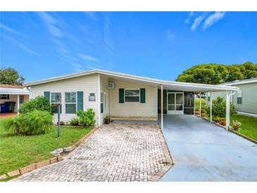 Single-wide manufactured home with covered carport and landscaped yard at 6762 Brentwood Ne Dr, Winter Haven, FL 33881