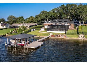 Luxury waterfront home with private dock, boat lift, and screened pool; expansive backyard at 1324 Mirror Nw Ter, Winter Haven, FL 33881