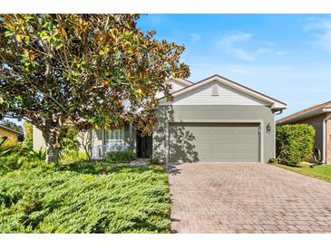 One-story house with green exterior, brick driveway, and landscaping at 4536 Turnberry Ln, Lake Wales, FL 33859