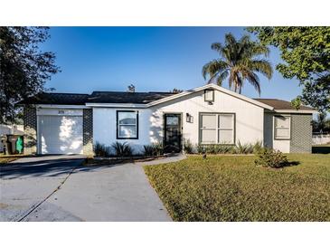 Charming single story home with a landscaped lawn and attached garage at 315 Lauderdale Ct, Kissimmee, FL 34759