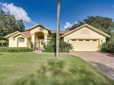 Nice yellow house with a large yard, mature trees, and a paved driveway at 1072 Old Cutler Rd, Lake Wales, FL 33898