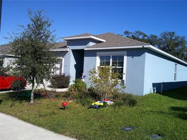 Single-story house with blue siding, landscaping, and a red car parked in the driveway at 3329 Lounging Wren Ln, Bartow, FL 33830