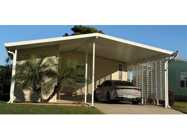 Mobile home with carport and landscaped yard at 418 Village Sw Cir, Winter Haven, FL 33880
