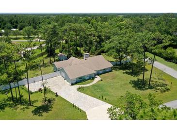 Aerial view of a single-story home with a large yard and paved driveway at 213 Riverbend Rd, Ormond Beach, FL 32174