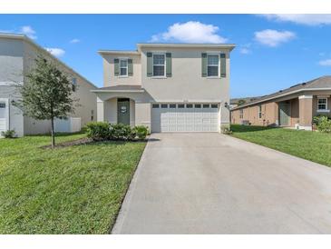Two-story home with attached garage and well-maintained lawn at 2557 Shamrock St, Tavares, FL 32778