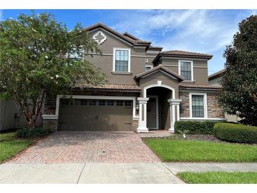 Two-story house with a brown facade and brick driveway at 1402 Wexford Way, Davenport, FL 33896