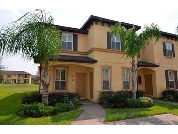 Two-story townhome with landscaping and walkway at 3001 Calabria Ave, Davenport, FL 33897