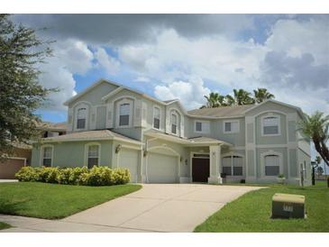 Two-story house with a three car garage and manicured lawn at 13900 Fox Glove St, Winter Garden, FL 34787