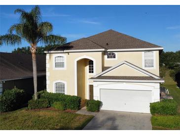 Two-story house with tan exterior, gray roof, and attached garage at 1821 Morning Star Dr, Clermont, FL 34714