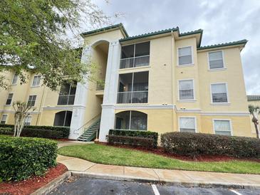 Two-story condo building with manicured landscaping at 8826 Dunes Ct # 207, Kissimmee, FL 34747
