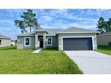 New construction home with gray exterior, two-car garage, and landscaped lawn at 274 Elm Ct, Kissimmee, FL 34759