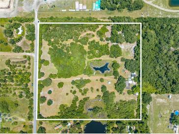 Aerial view of a large lot with mature trees and a pond at 1235 Hackney Rd, St Cloud, FL 34771
