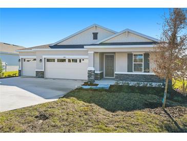 Two-story house with a two-car garage, stone accents, and a landscaped yard at 4260 Sawtooth Ct, Tavares, FL 32778