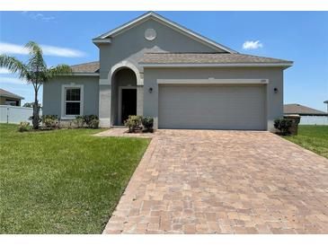Single-story house with a two-car garage and a paved driveway at 2757 Creekmore Ct, Kissimmee, FL 34746