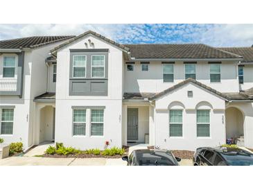 Two-story townhome with gray door and landscaping at 301 Captiva Dr, Davenport, FL 33896