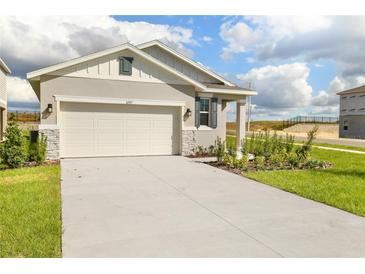 Front view of charming house with a two-car garage and landscaped yard at 6357 Clover St, Lake Hamilton, FL 33851
