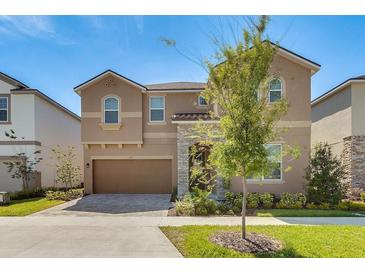Two-story home with a neutral facade and landscaping at 1770 Sawyer Palm Pl, Kissimmee, FL 34747