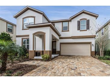 Two-story house with a beige garage and brick driveway at 1754 Caribbean View Ter, Kissimmee, FL 34747