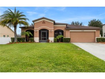 One-story house with a two-car garage and palm trees at 840 Crooked Branch Dr, Clermont, FL 34711