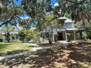 Two-story home nestled amongst lush greenery, showcasing a charming facade at 2086 Camelot Blvd, St Cloud, FL 34772
