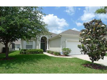 Single-story home with a two car garage and lush landscaping at 648 Copeland Dr, Haines City, FL 33844