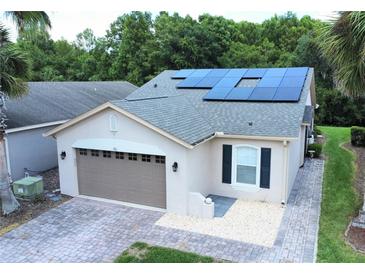 Single-story house with solar panels and a two-car garage at 561 Vineyard Way, Poinciana, FL 34759