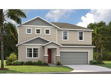 Two-story home with gray and beige siding and a two car garage at 1635 Sugarbelle Cir, Mascotte, FL 34753