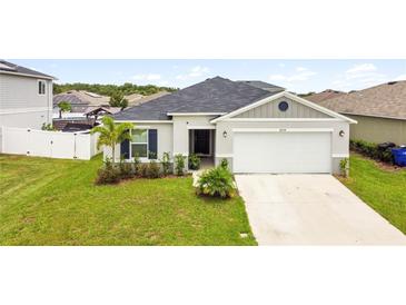 Charming single-story home with a two-car garage and landscaped front yard at 2894 Mosshire Cir, Saint Cloud, FL 34772
