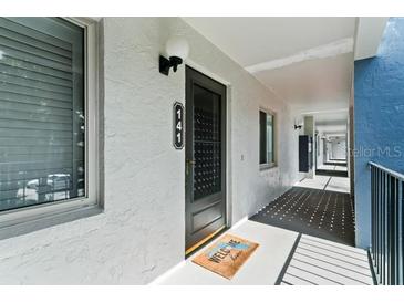 Building exterior with walkway and black door at 15 Escondido Cir # 141, Altamonte Springs, FL 32701