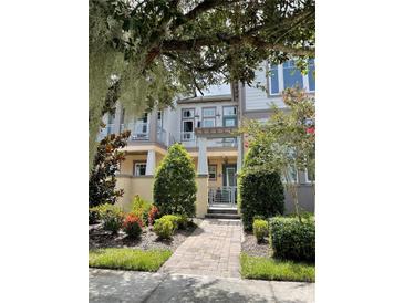 Charming townhome with landscaped walkway and lush greenery at 8079 Nemours Pkwy, Orlando, FL 32827