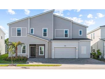 Modern two-story house with gray siding and two-car garage at 1735 Oak Blossom Dr, Davenport, FL 33837