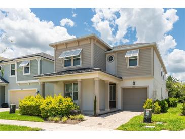 Two story house with light beige siding and dark roof at 8963 Amelia Downs Trl, Kissimmee, FL 34747
