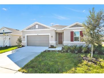 One-story home with gray siding, red shutters, and a two-car garage at 3104 Kacee Dr, Eagle Lake, FL 33839