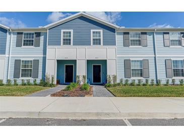 Two-story townhouses with blue siding and gray shutters at 3725 Pacific Ln, Davenport, FL 33897
