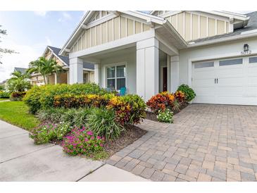 Inviting front yard with colorful landscaping and brick pavers at 5012 E Fountainwood Dr, St Cloud, FL 34772
