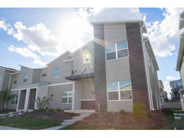 Modern two-story townhome with stone accents at 1038 Splash Shot Pl, Davenport, FL 33896