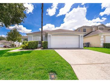 Single story home with attached garage and well-manicured lawn at 104 Langham Dr, Davenport, FL 33897