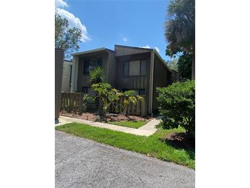 Dark brown two-story condo with wood siding and a small fenced yard at 5341 Indian Creek Dr # B, Orlando, FL 32811