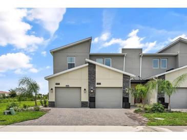 Modern two-story townhome with two-car garage and attractive exterior finishes at 9355 Sommerset Hills Dr # 9355, Davenport, FL 33896