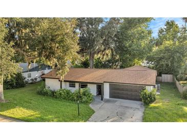 Ranch style home with brown roof and dark garage door at 3722 Paige St, Port Orange, FL 32129