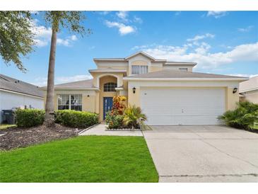 Two-story house with attached garage, landscaping and driveway at 241 Grosvenor Loop, Davenport, FL 33897