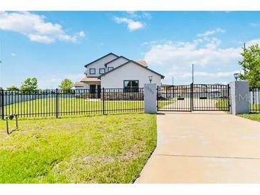 Two-story home with gated entrance and landscaping at 1980 Poblado Ct, Kissimmee, FL 34744