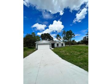 New construction home with gray siding and a two-car garage at 1339 Tallahassee Ct, Kissimmee, FL 34759