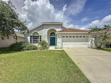House exterior with teal door and attached garage at 744 Stonewyk Way, Kissimmee, FL 34744