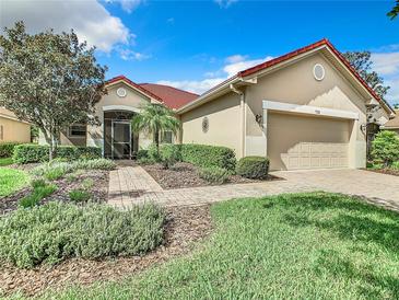 Single-story home with red tile roof, neutral exterior, and landscaped front yard at 722 Coronado Dr, Kissimmee, FL 34759