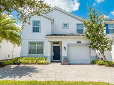 Two-story house with white exterior, paver driveway and landscaping at 4722 Sleepy Hollow Dr, Kissimmee, FL 34746