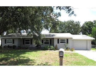 Ranch style home with grey siding and a two-car garage at 896 N 9Th St, Eagle Lake, FL 33839