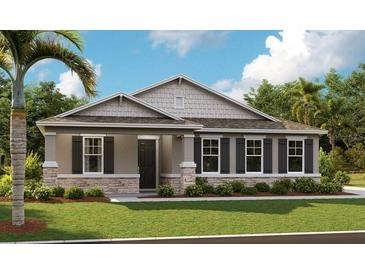 One story house with gray siding, stone accents, and landscaping at 3896 Deer Ridge Dr, Mount Dora, FL 32757